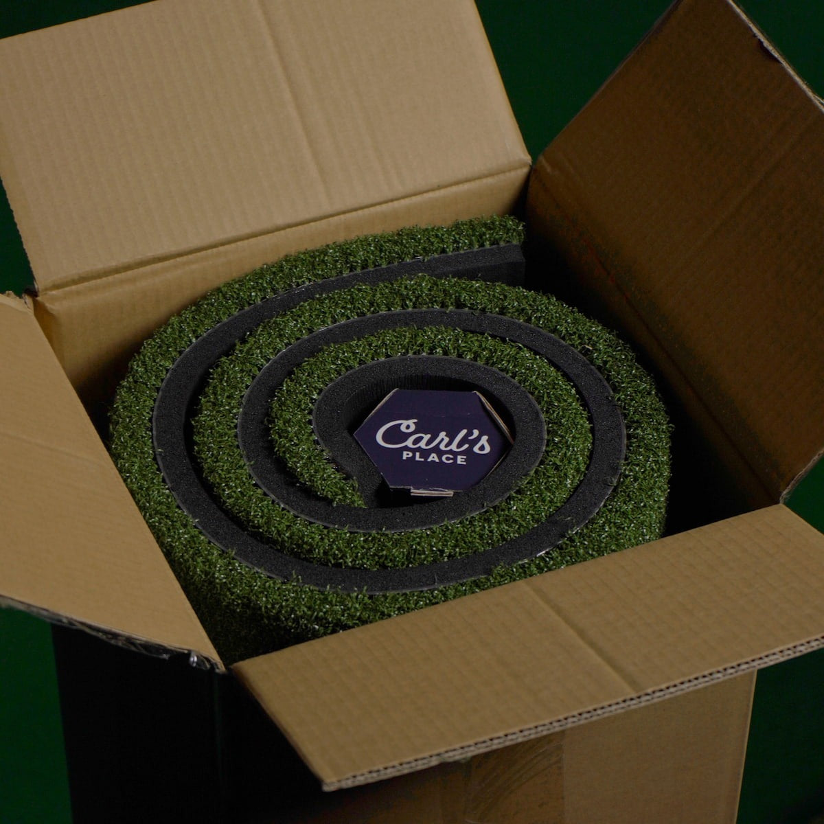 Carl's Place HotShot™ Hitting Mat - mat rolled inside an open cardboard shipping box with a branded label