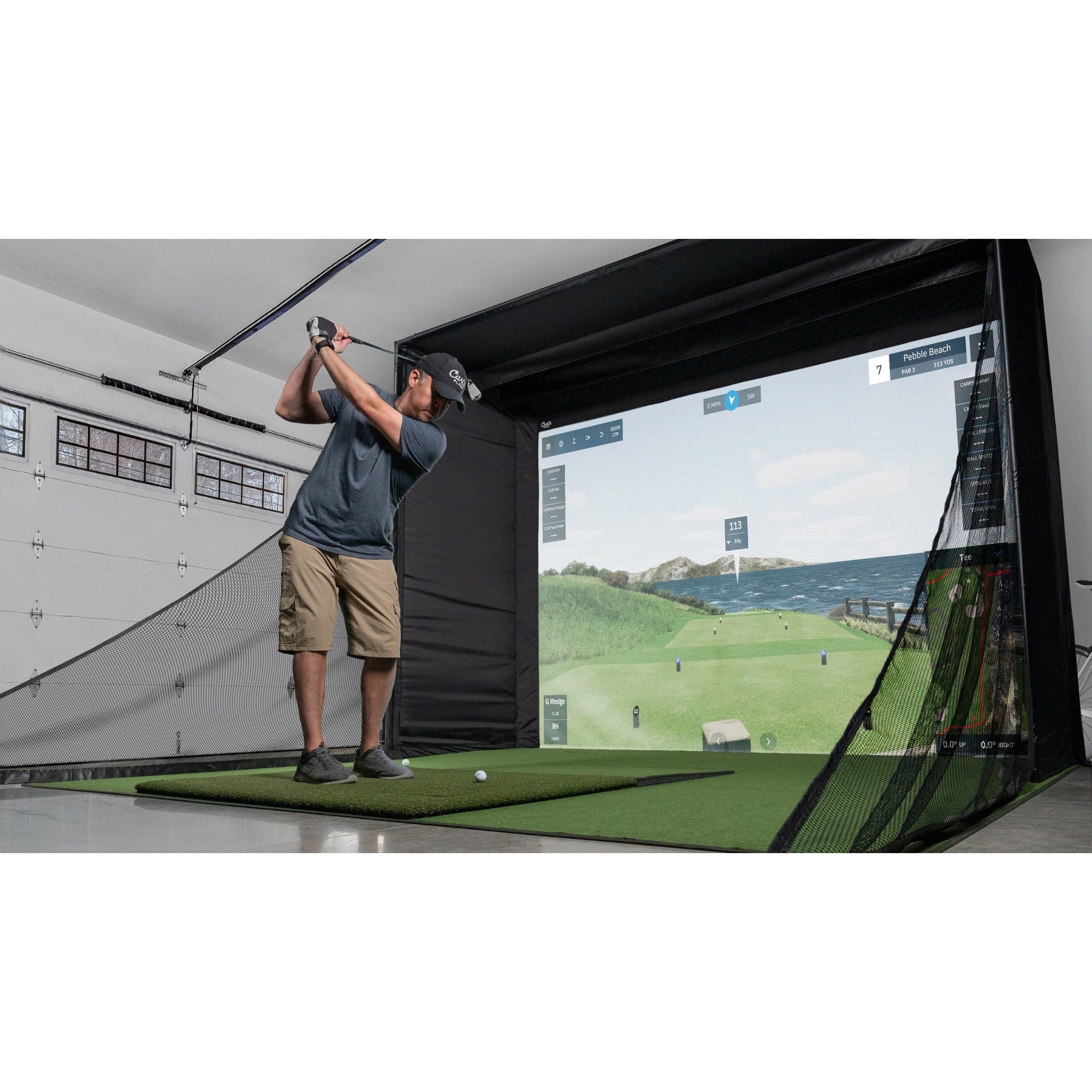 Carl's Place DIY Golf Simulator Enclosure Kit - golfer swinging into the netted enclosure in a converted garage bay