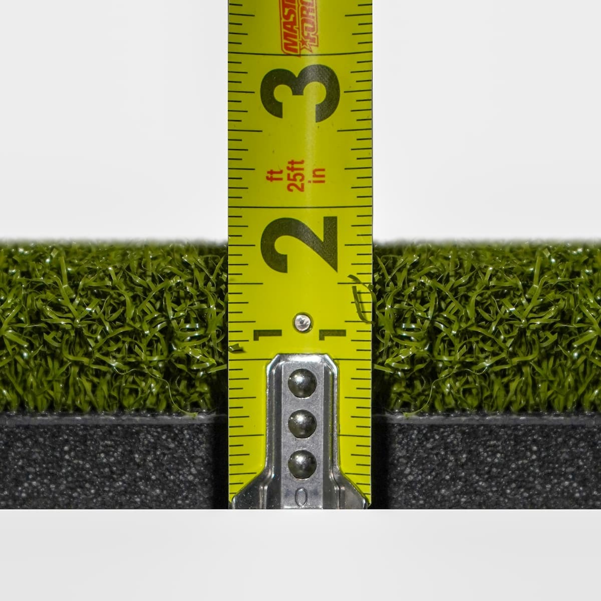 Carl's Place HotShot™ Hitting Mat - tape measure held against the edge showing turf and black foam layer depth