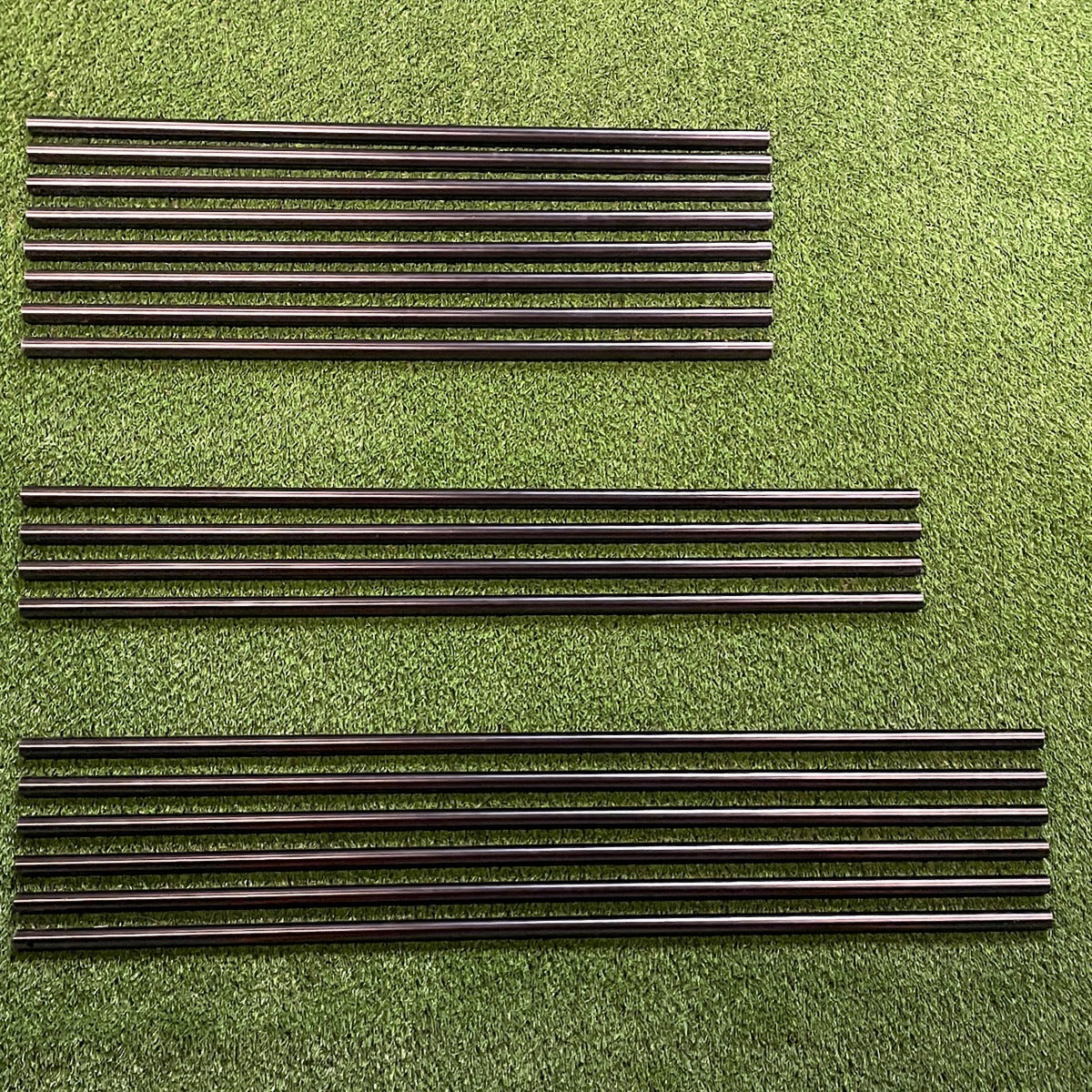 Carl's Place DIY Golf Simulator Enclosure Kit - pre-cut steel EMT pipes for the optional Pipe Framing Kit laid on turf